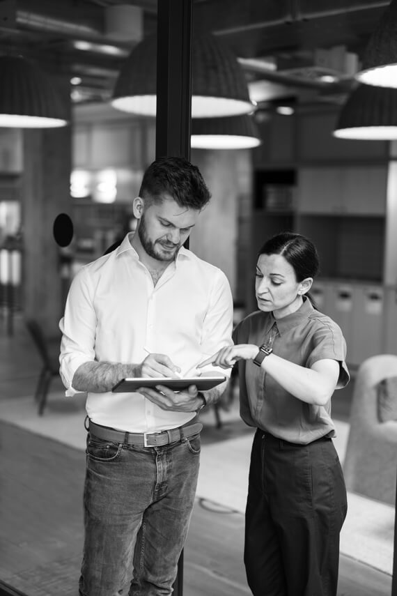 two people standing next to each other and one has a tablet