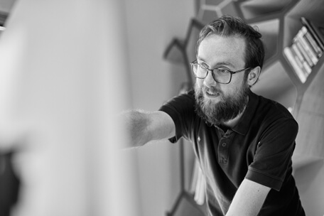 a man with a beard and glasses pointing at something.