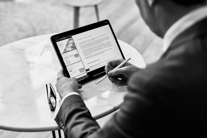 one man sitting at table and working on tablet laptop